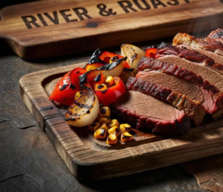Selection of River & Roast signature wood-fired dishes arranged on a dark table beside the grill